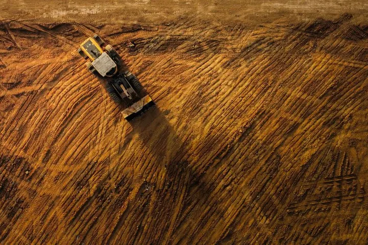 Bulldozer moving earth at a construction site, viewed from above