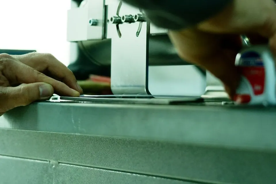 Hands adjusting a machine in a workshop